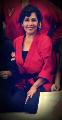 Frances Walker holding a certificate at a martial arts ceremony